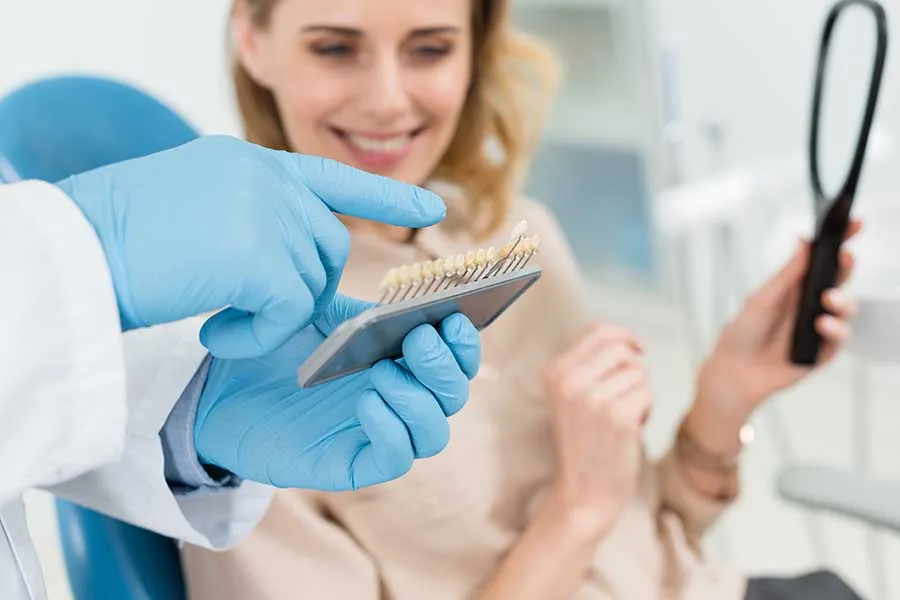 Female patient choosing a dental crown that matches her tooth color. 