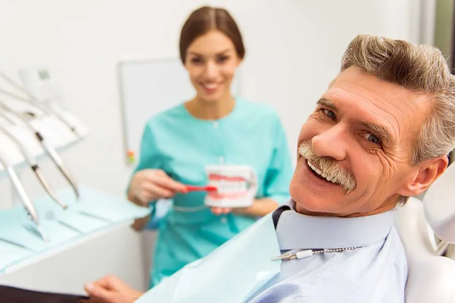 Older gentleman smiling after receiving a new set of dentures in Las Vegas. 