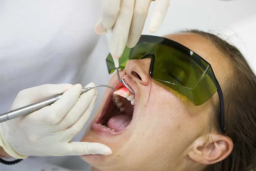 Female patient wearing protective goggles as she receives laser dental treatment in Las Vegas. 